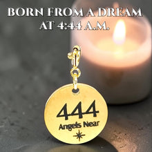 Load image into Gallery viewer, Gold pendant with '444 Angels Near' text in front of a blurred candle