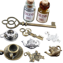 Load image into Gallery viewer, A collection of 10 bronze and glass charms featuring Alice in Wonderland themed designs, including a tea pot, cup, key, and rabbit figures.