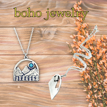 Load image into Gallery viewer, Boho jewelry with mountain and moon design on a wooden background