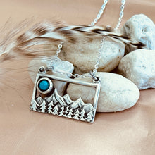 Load image into Gallery viewer, Silver necklace with mountain and turquoise stone pendant on pebbles and feathers