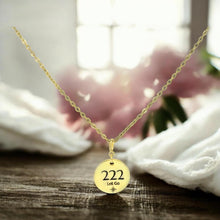 Load image into Gallery viewer, Gold necklace with a pendant featuring the number 222 on a wooden surface.