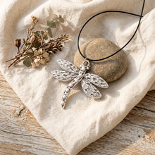 Load image into Gallery viewer, Boho lifestyle flat lay of dragonfly necklace on linen and light oak wood