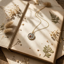 Load image into Gallery viewer, Gold celestial sun and moon coin necklace on vintage book aesthetic flat lay